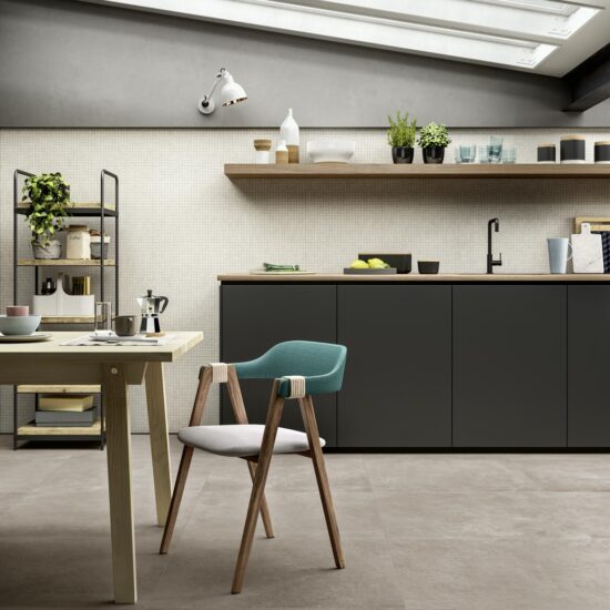 Keuken met een grijze betonlook vloer, een donkere kastenwand en een houten eettafel