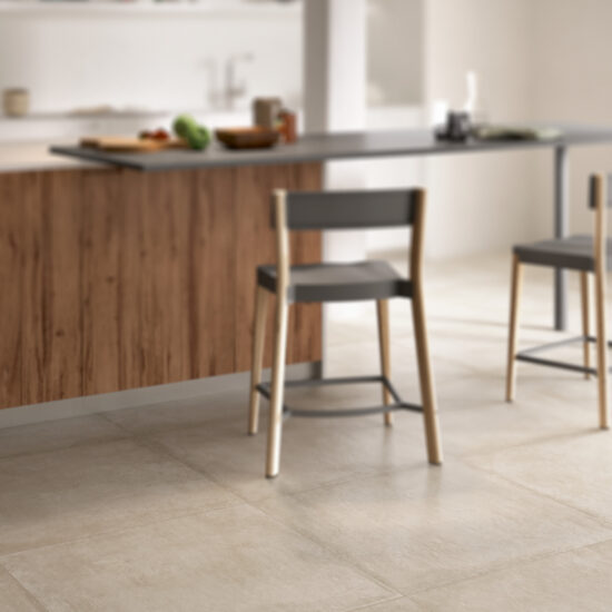 Keuken met een warme, crèmekleurige betonlookvloer, een houten eiland en twee krukken